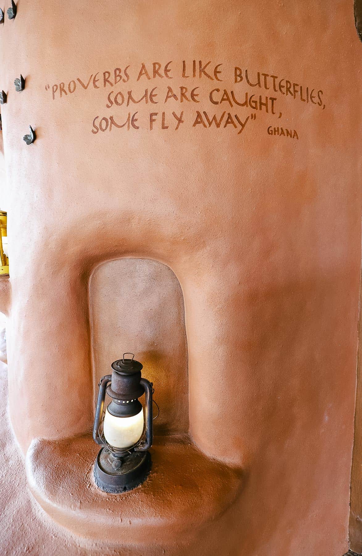 a proverb painted on a wall in the lobby that says, " Proverbs are like butterflies, some are caught, some fly away." Ghana