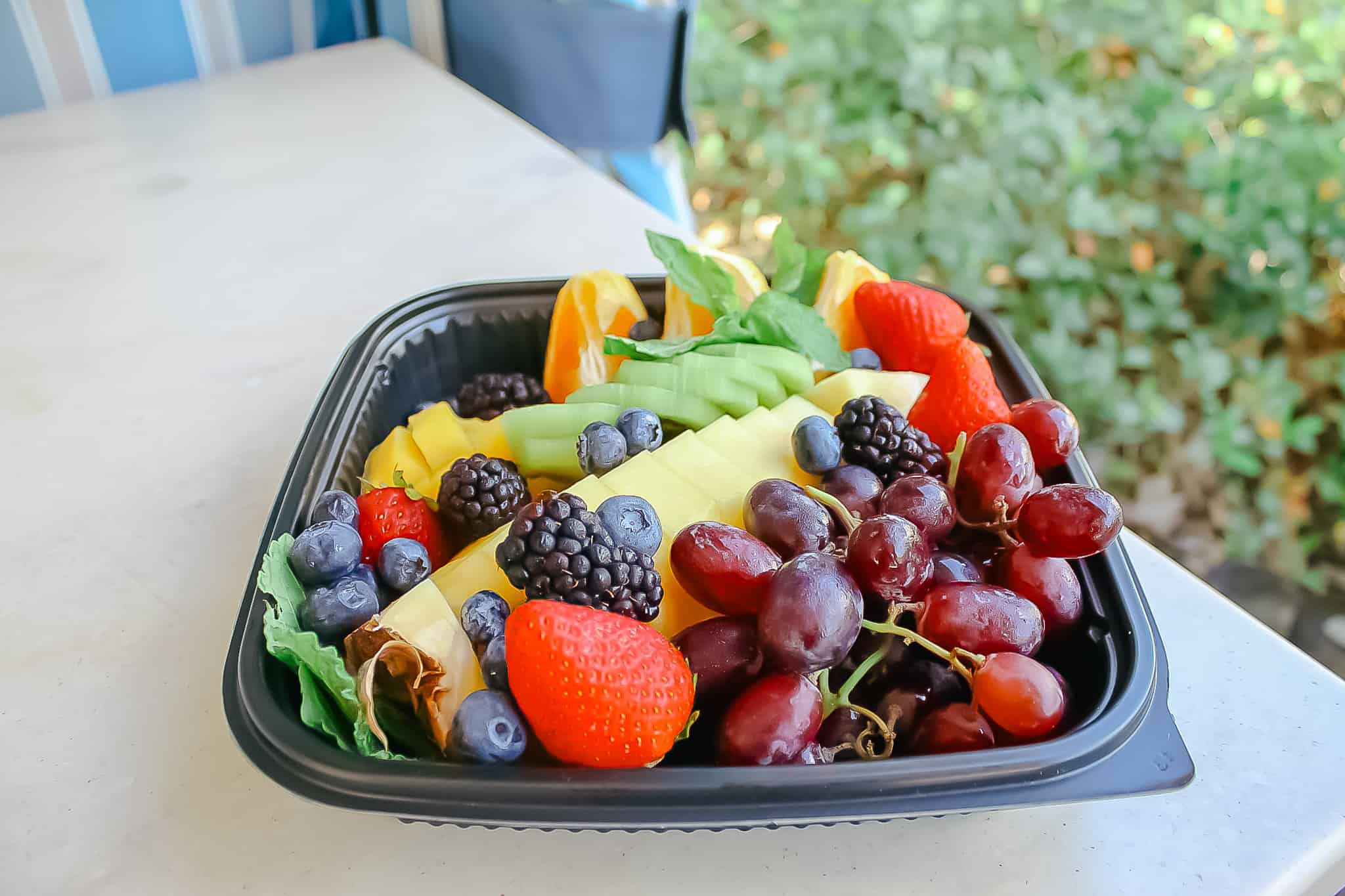a fruit tray with strawberries, grapes, pineapple, kiwi, and more
