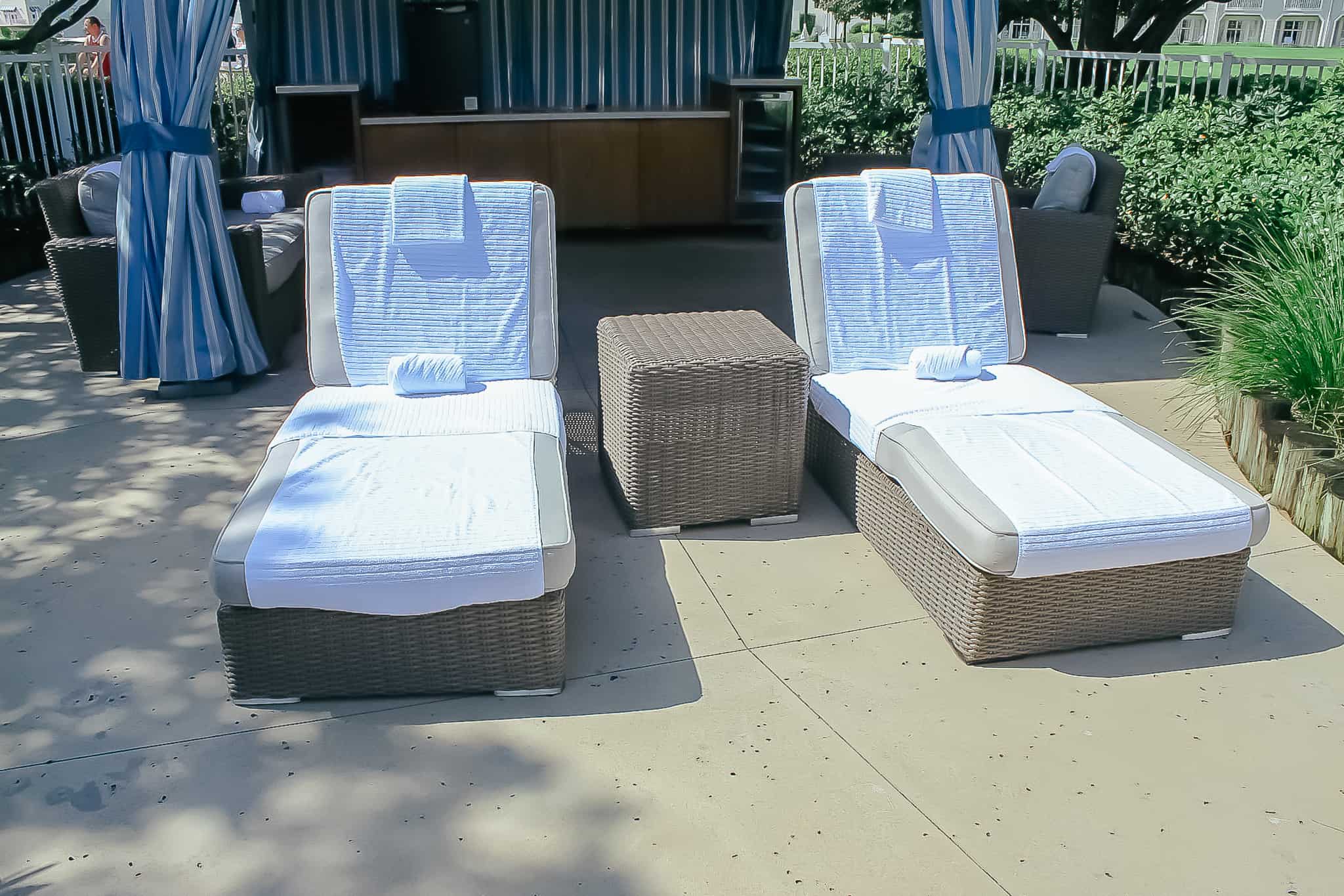 two lounge chairs with a side table between them