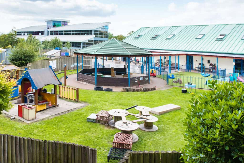 Colourful outdoor childcare playground with playhouses, swings, and climbing structures at Thrive Childcare, providing a safe, engaging environment for young children to learn and play.