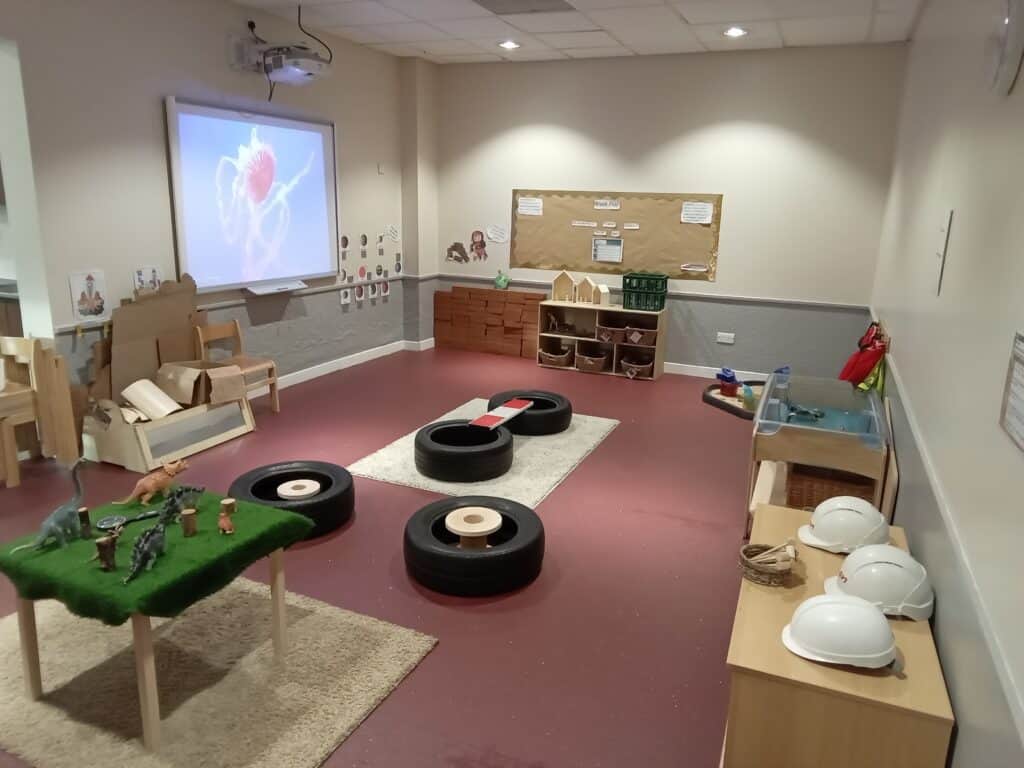 Colourful indoor toddler play area with toys, soft tyres, and educational displays at Thrive Childcare, highlighting a safe, engaging environment for early childhood development and learning.