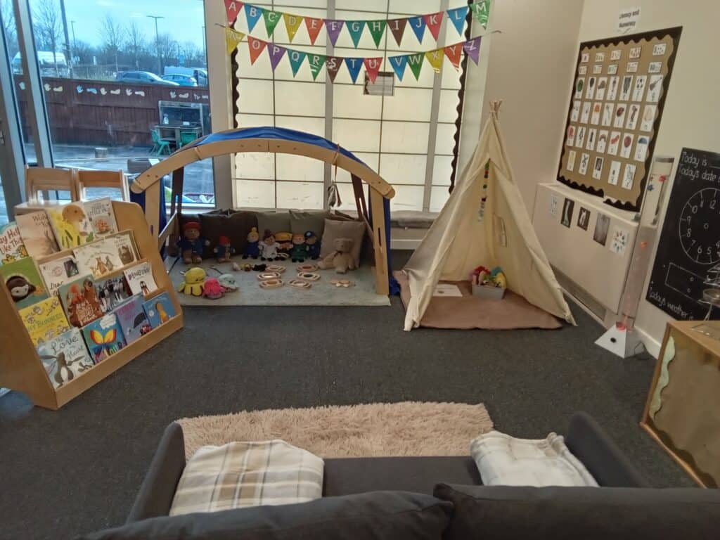 Bright indoor play area at Thrive Childcare with soft toys, books, and a children's reading and activity corner, fostering early childhood development and learning.