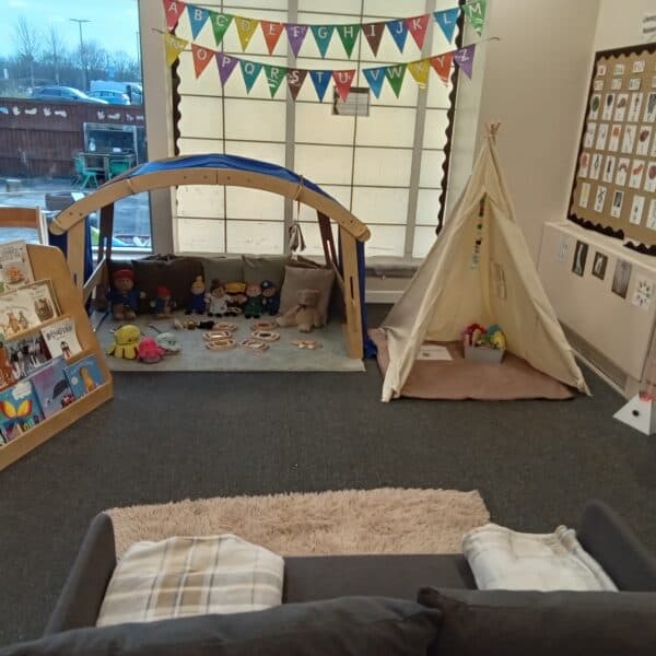 Bright indoor play area at Thrive Childcare with soft toys, books, and a children's reading and activity corner, fostering early childhood development and learning.
