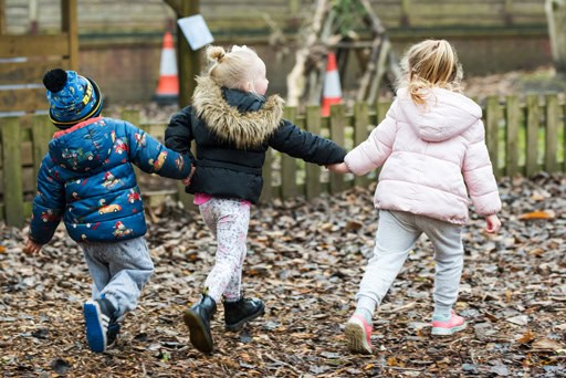 Bright children playing outdoors at Thrive Childcare, exploring nature, developing social skills, and enjoying supervised play in a caring educational environment.