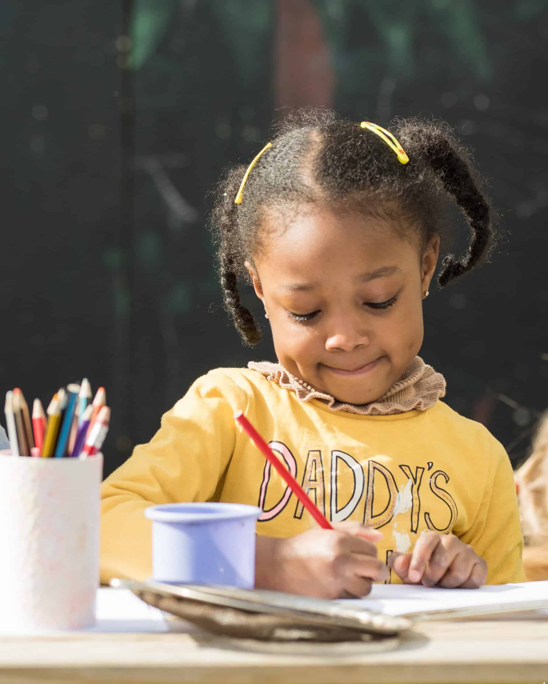 Bright young girl engaging in creative activities at Thrive Childcare, showcasing a nurturing environment that promotes early childhood development and learning.