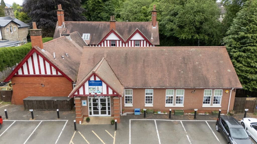 Bright and welcoming childcare centre with red and white striped details, modern facilities, and nearby parking, offering a safe, nurturing environment for children's early education and development.