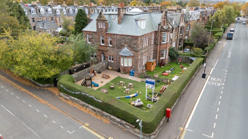 Bright outdoor playground area for children at Thrive Childcare in a historic building, with toys, play structures, and safe fencing for early childhood education and outdoor fun.