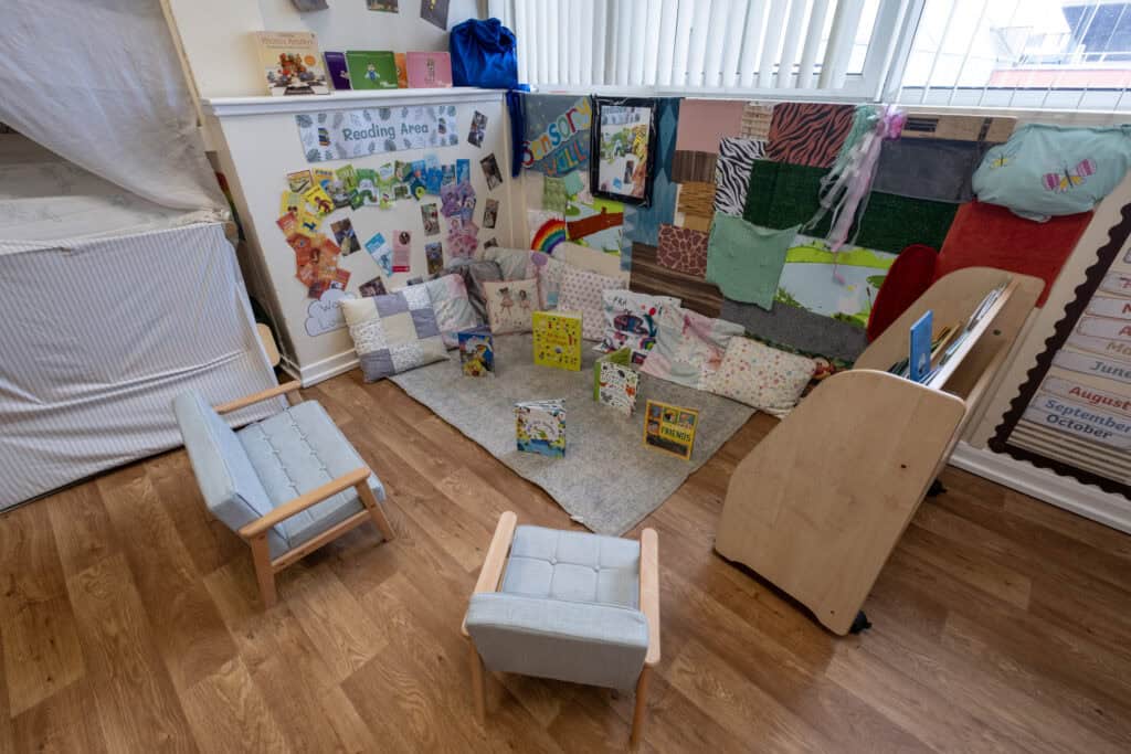 A colourful reading corner in a childcare setting, featuring books, cushions, and reading displays to foster literacy skills in young children. Perfect for early childhood education environments.