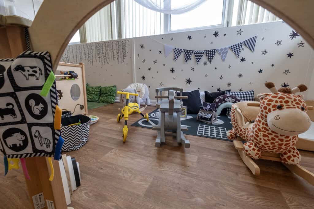 Bright and welcoming childcare play area with colourful toys, soft cushions, and animal-themed decor, perfect for fostering early childhood development and learning at Thrive Childcare.