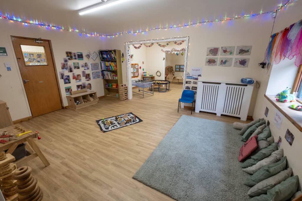 Bright and spacious childcare indoor play area with colourful decorations, toys, and learning resources, perfect for young children’s development and creativity.