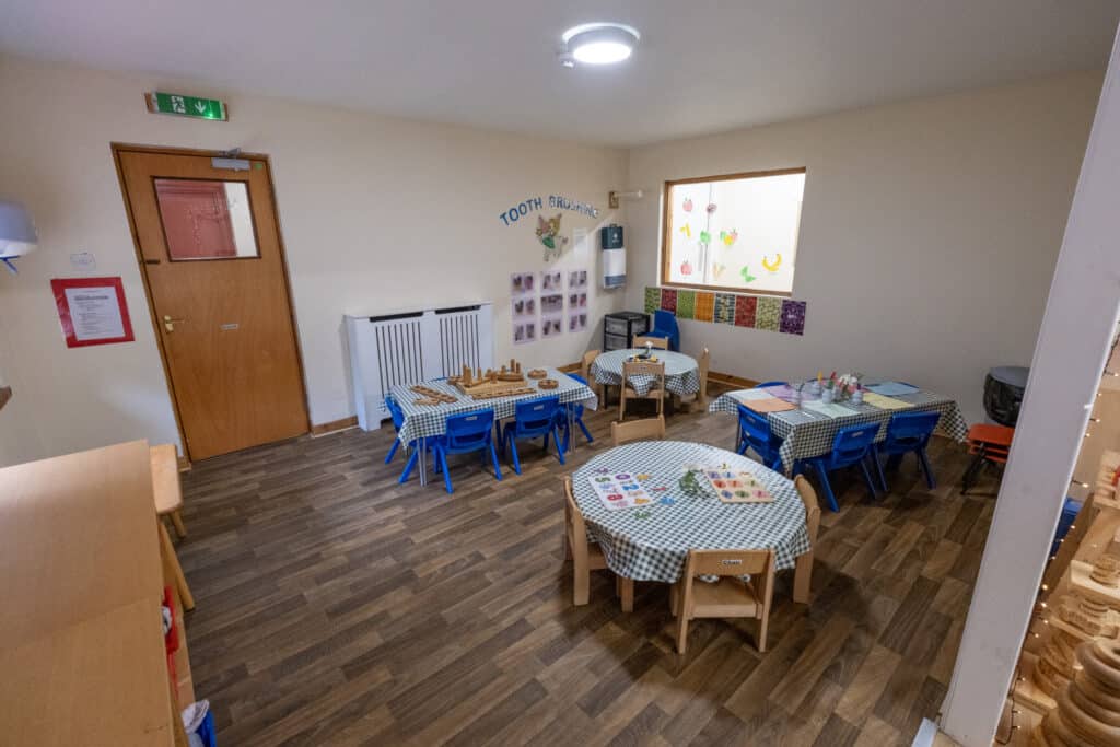 Bright nursery classroom at Thrive Childcare featuring child-sized tables, educational toys, colourful decorations, and a welcoming environment for early childhood learning and development.