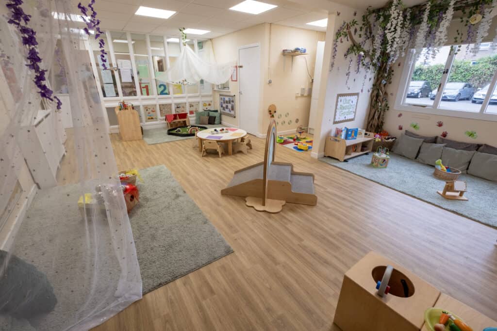 Bright, welcoming nursery playroom at Thrive Childcare with soft rugs, natural light, and diverse play areas designed to stimulate early childhood development and learning.