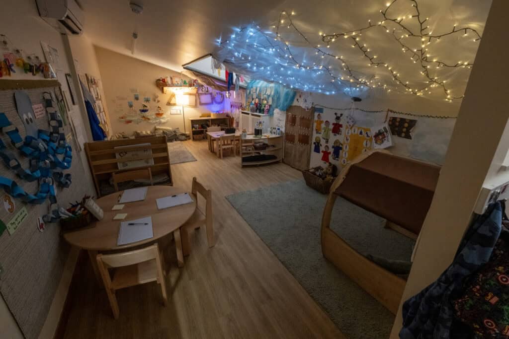 Bright, colourful early childhood learning space at Thrive Childcare featuring educational materials, cosy corner, and artistic decorations for supporting children's growth and development.