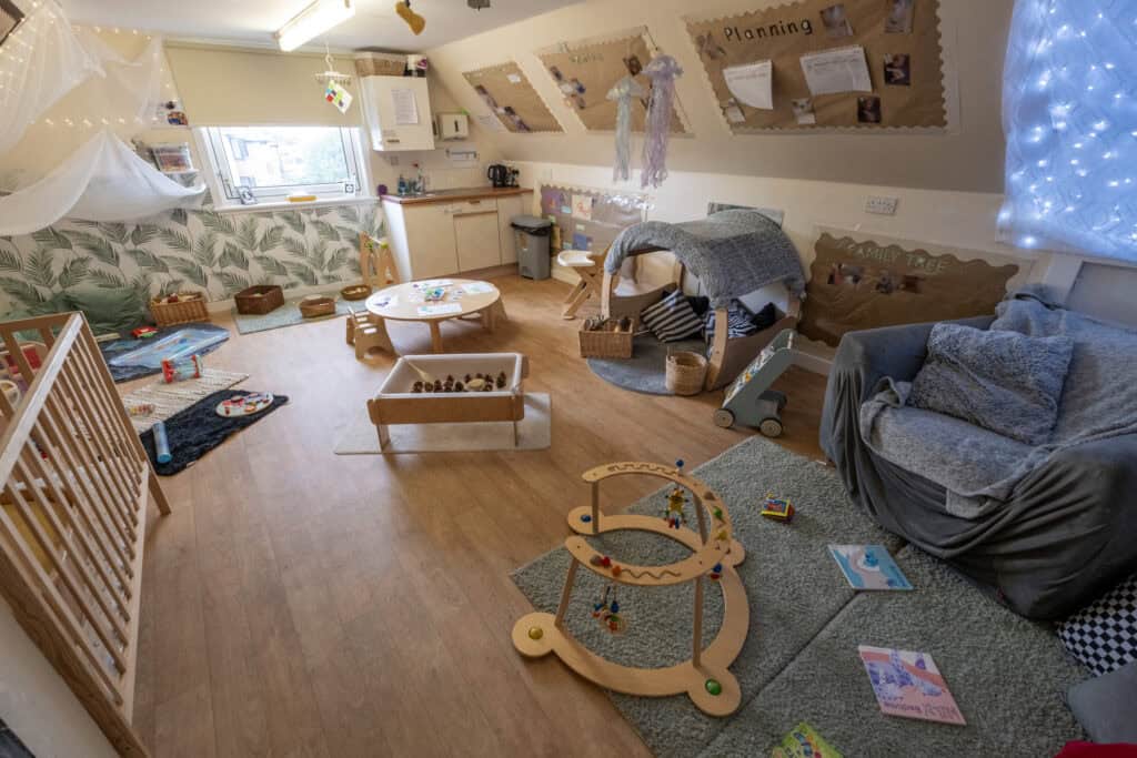 Bright and inviting childcare playroom with toys, books, and cozy seating, designed to support child development and learning, perfect for early childhood education at Thrive Childcare.