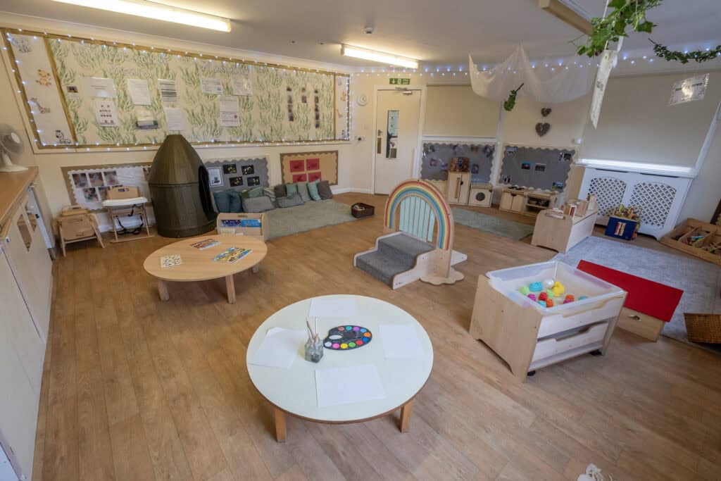 Bright, welcoming nursery playroom at Thrive Childcare with soft lighting, colourful decorations, and children's learning and play areas designed to promote early childhood development and safe, engaging childcare.