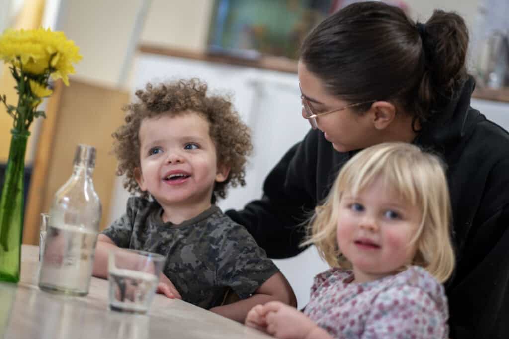 A diverse childcare environment with happy children and caring staff at Thrive Childcare, promoting early childhood development, learning, and nurturing care services in a supportive setting.