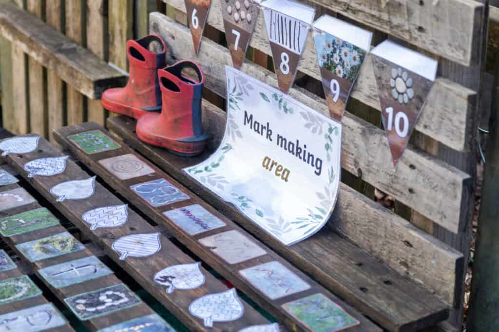 Bright children's rain boots and a colourful mark making area at Thrive Childcare outdoor activity zone, encouraging early childhood development and outdoor play for young kids.