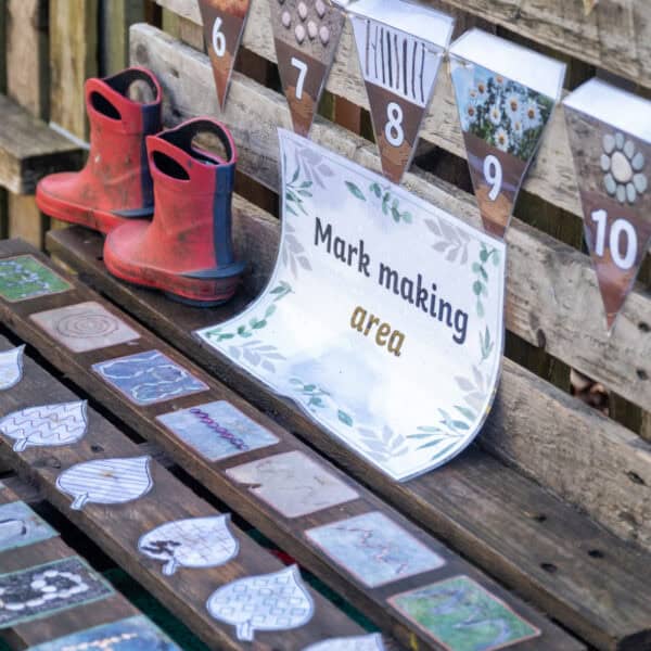 Bright children's rain boots and a colourful mark making area at Thrive Childcare outdoor activity zone, encouraging early childhood development and outdoor play for young kids.