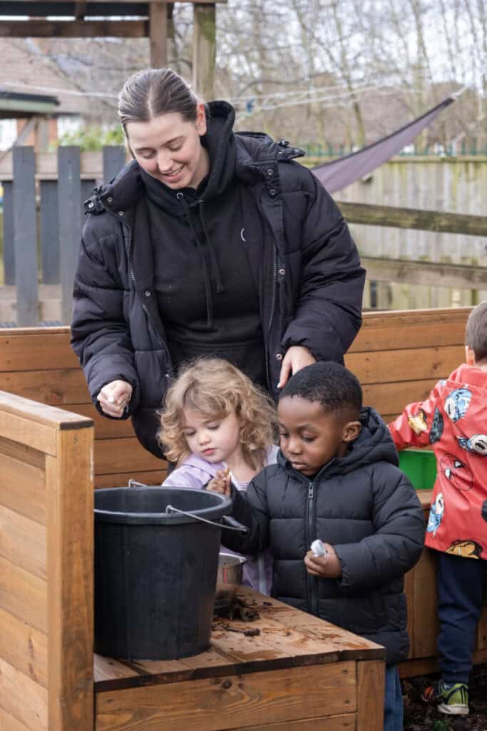 1. Friendly childcare staff engaging children in outdoor activities at Thrive Childcare, promoting early learning and social development in a safe environment.