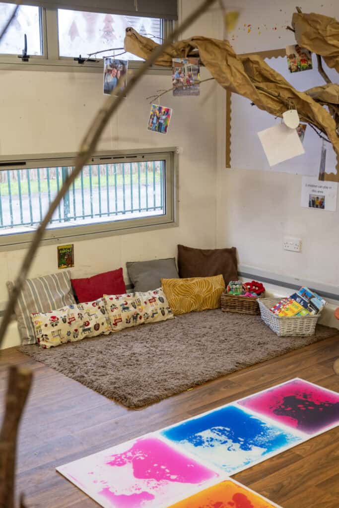 Bright, inviting children's reading and play area at Thrive Childcare with cushions, children's books, and colourful artwork for fostering early development and learning.