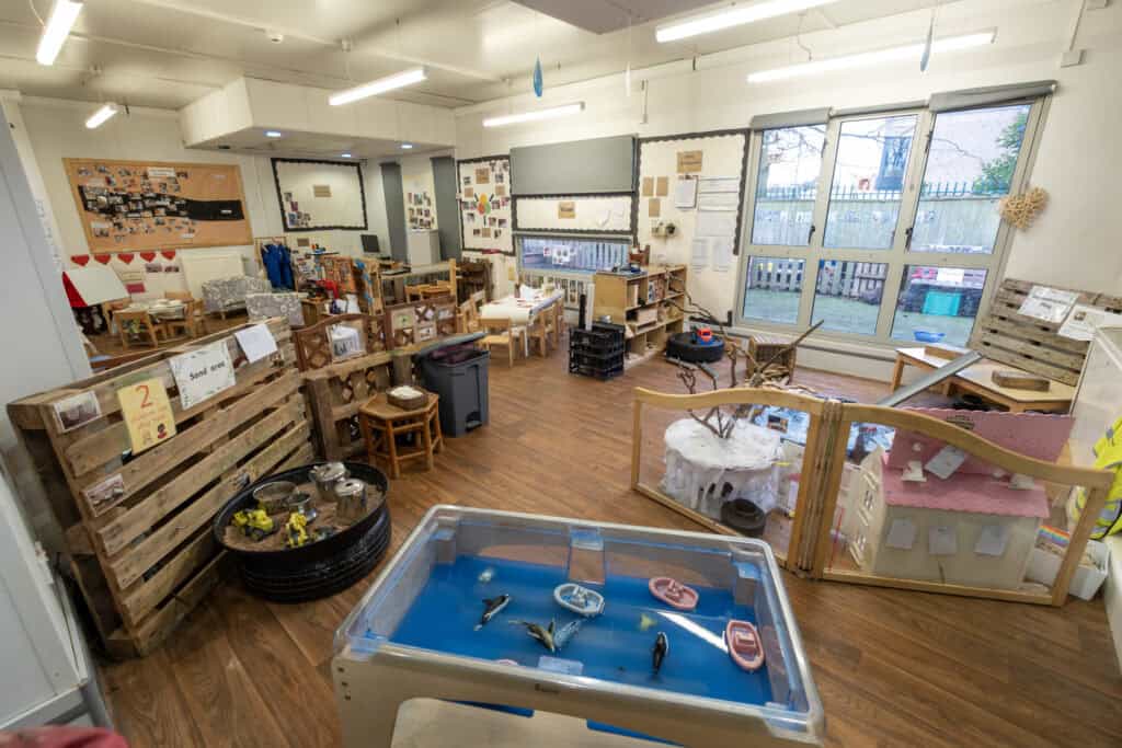 Bright indoor childcare room with play areas, educational materials, and toys, promoting learning and development for children at Thrive Childcare in a safe and nurturing environment.
