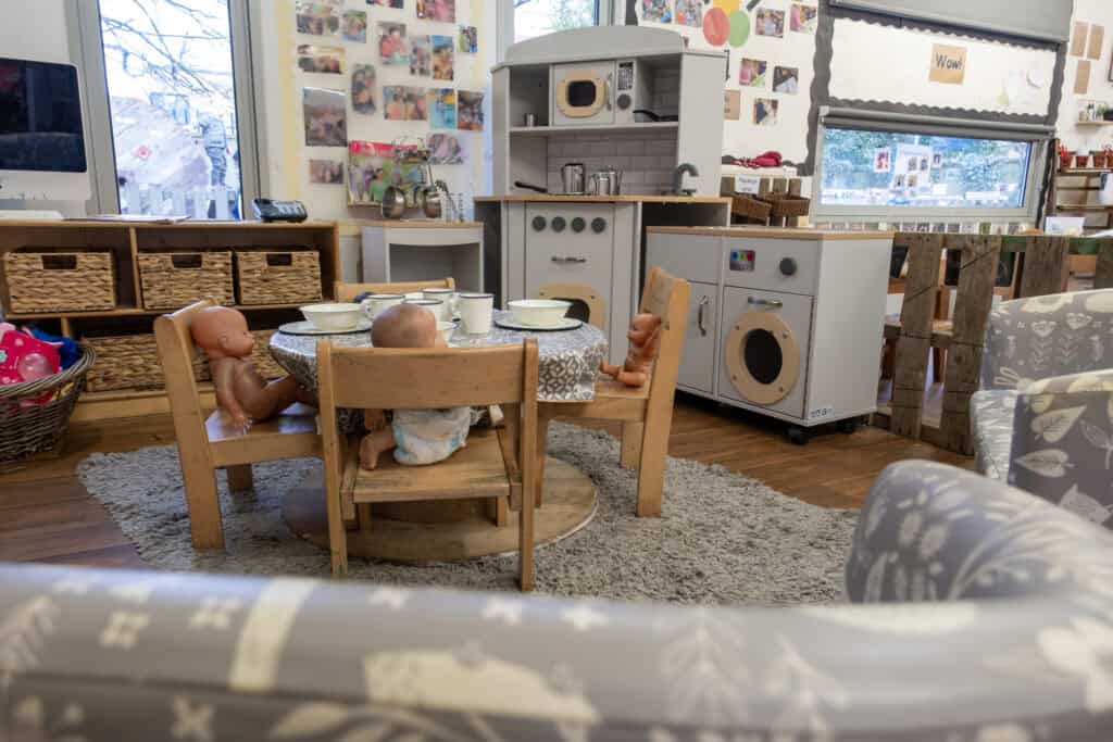 Soft play kitchen area with children's toys, dolls, and play food, creating a safe and engaging environment for preschoolers at Thrive Childcare.