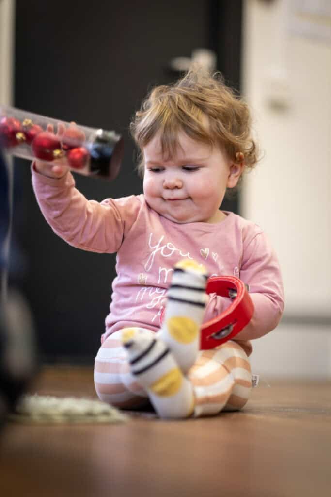 1. Adorable toddler playing with toys in a nurturing childcare environment at Thrive Childcare, promoting early childhood development and learning.
