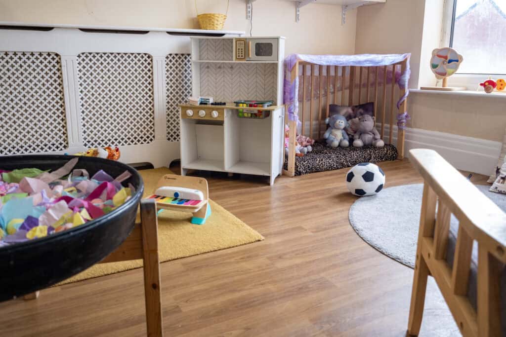 1. Bright indoor play area at Thrive Childcare with toys, stuffed animals, a mini kitchen, and soft play space for young children’s early learning and development.