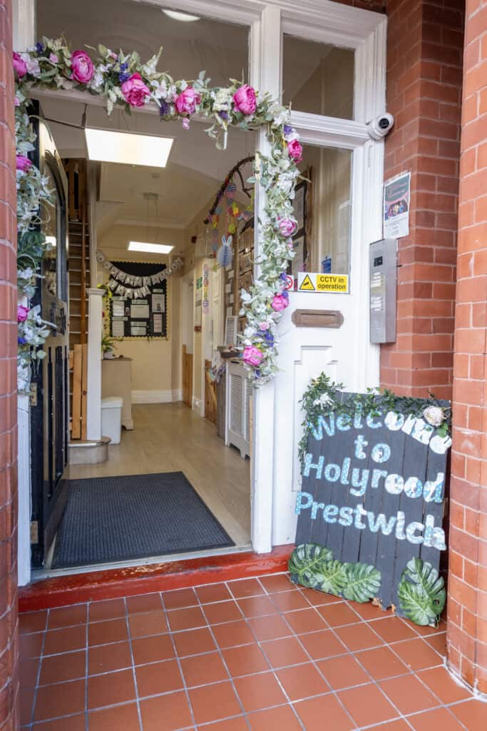 Bright flower-decorated entrance of Thrive Childcare in Holyrood Prestwich, welcoming children and parents to a safe, caring, and engaging early years education environment in Manchester.