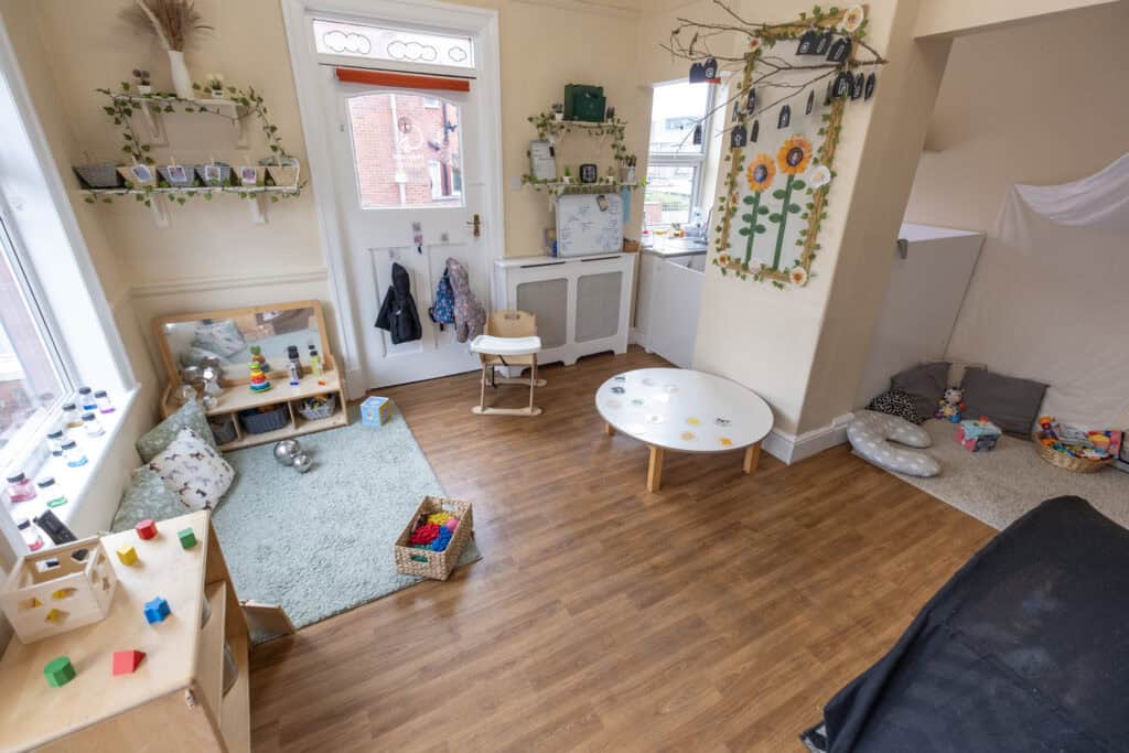 Bright and welcoming Thrive Childcare indoor playroom with educational toys, cosy reading nook, and colourful decorations, creating a safe environment for early childhood development and learning.