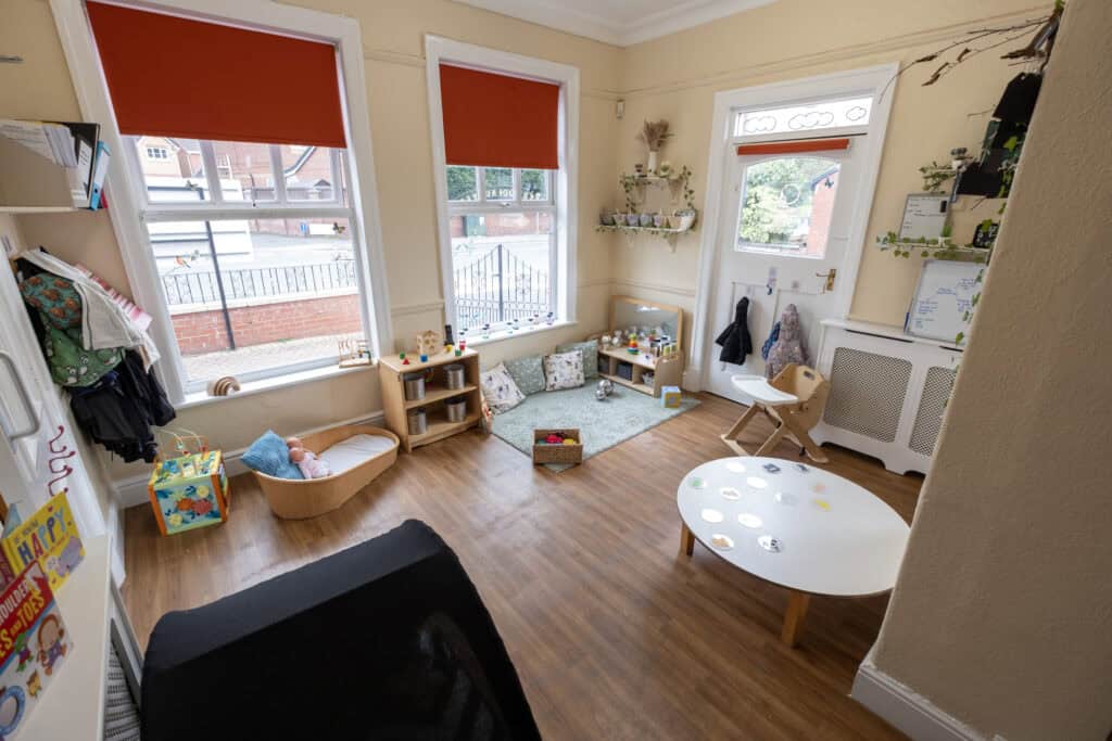 Soft playroom for children with large windows, colourful toys, and cosy cushions, perfect for early childhood development at Thrive Childcare in a bright, welcoming environment.