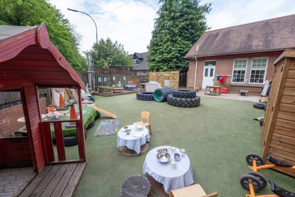 Bright outdoor childcare playground with playhouses, age-appropriate toys, sensory activities, and safe soft flooring for children’s play and development at Thrive Childcare.