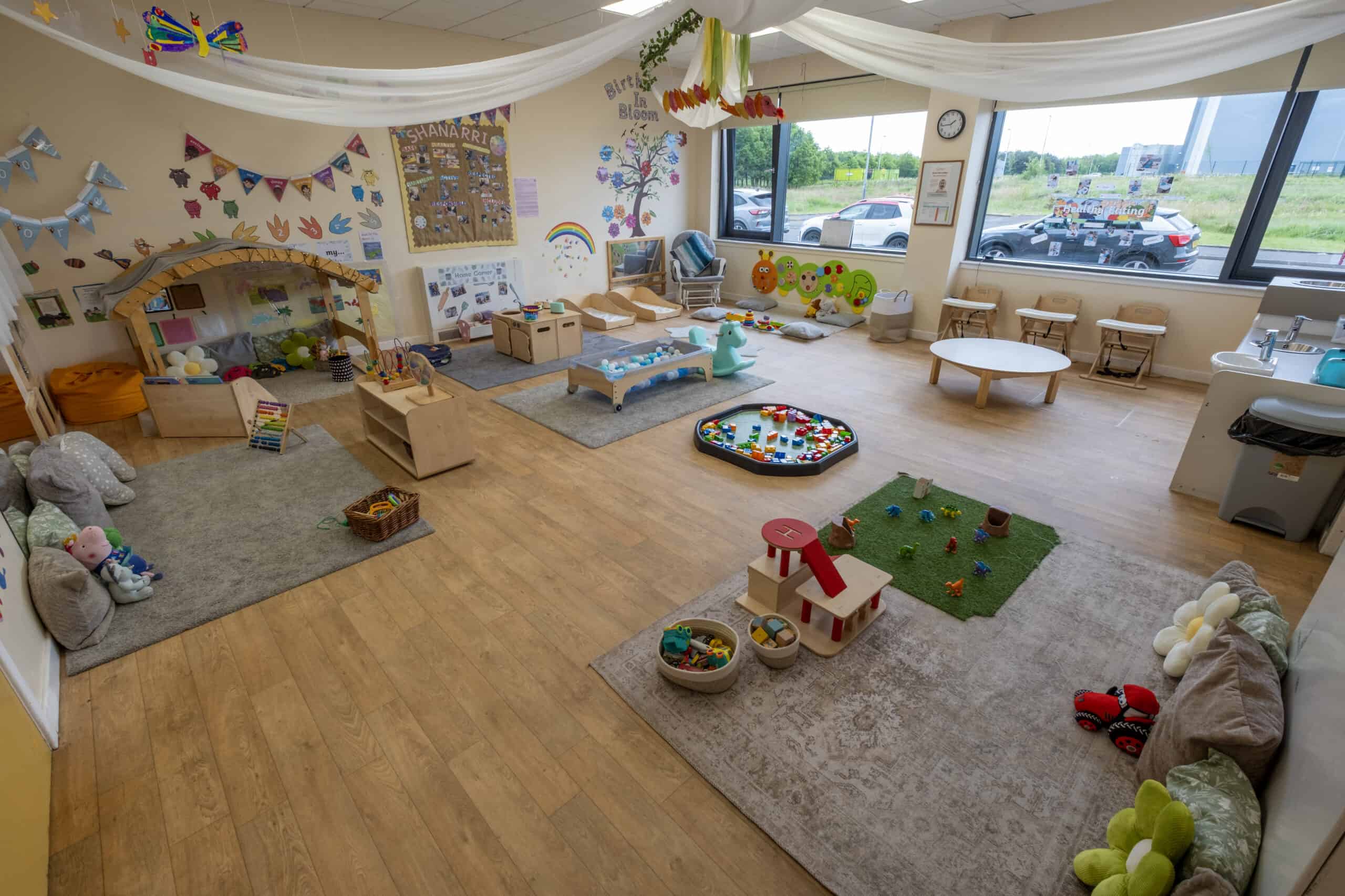 Bright, inviting toddler playroom at Thrive Childcare featuring colourful toys, cosy reading areas, and educational decorations to support early childhood development and learning in a safe environment.