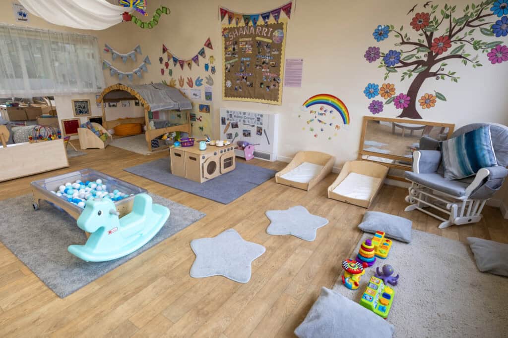 Bright and welcoming indoor play area at Thrive Childcare with soft mats, toys, a kitchen corner, and cosy zones to support early childhood development and imaginative play.