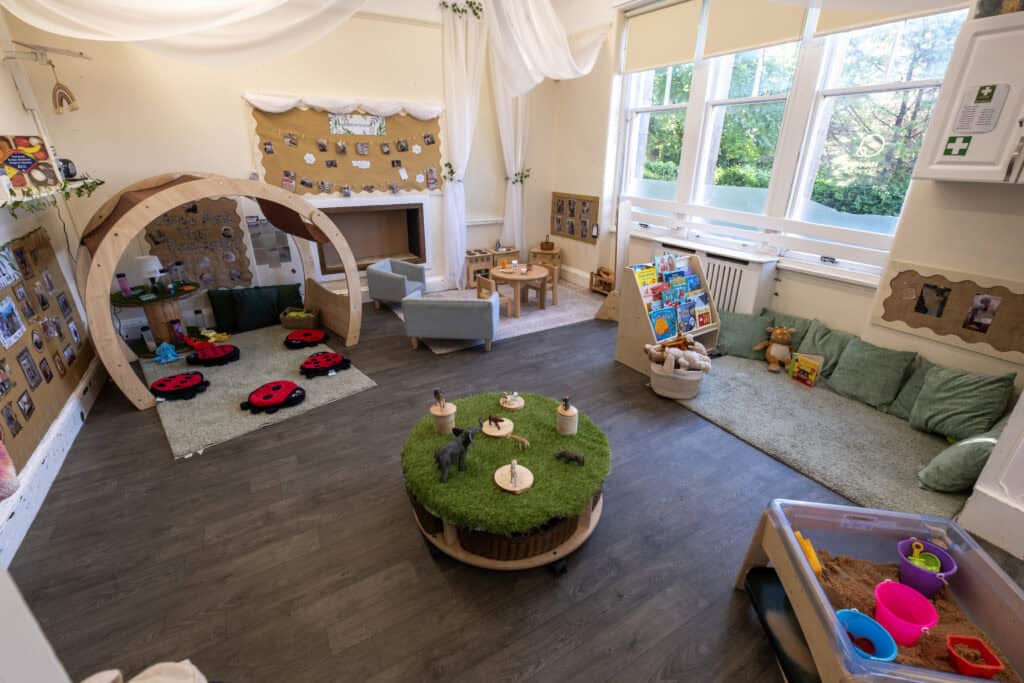 Bright and welcoming childcare playroom with cozy seating, sensory play area, storybooks, and educational toys, designed to promote learning and development for young children at Thrive Childcare.