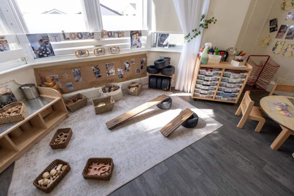 Cozy early childhood classroom with natural wooden toys, sensory bins, and art supplies for fostering learning and play at Thrive Childcare in the UK.