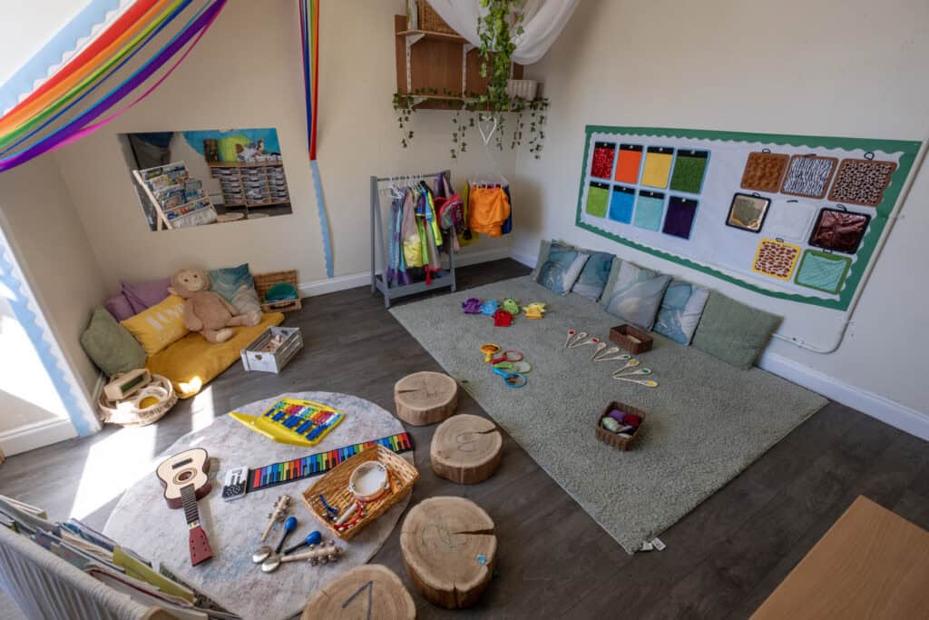 A colourful, inviting early childhood learning and playroom at Thrive Childcare, featuring toys, educational materials, comfy cushions, and visual aids to support child development and learning.