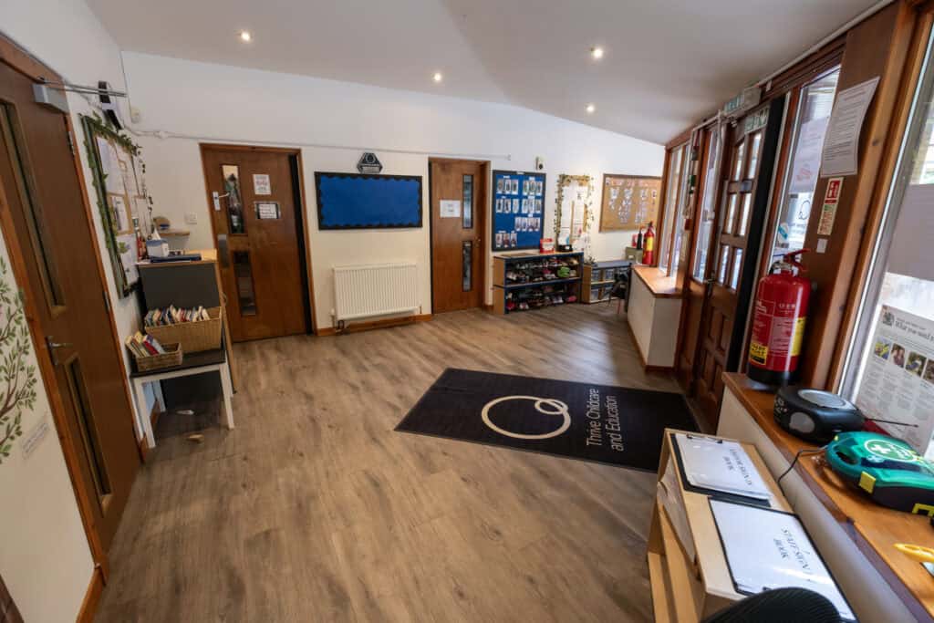 Bright, welcoming early childhood education centre with polished wooden floors, colourful decor, educational displays, and emergency safety equipment, designed to support children's learning and development.