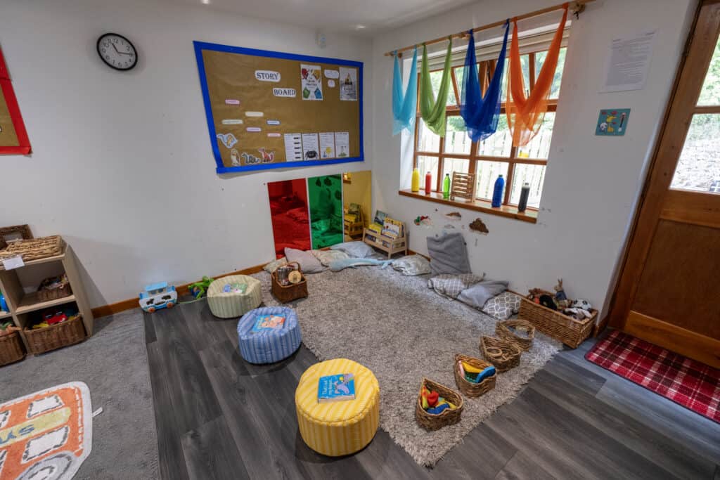 Bright early childhood learning space at Thrive Childcare with colourful curtains, assorted toys, comfy cushions, and educational decor, fostering a nurturing environment for toddlers.