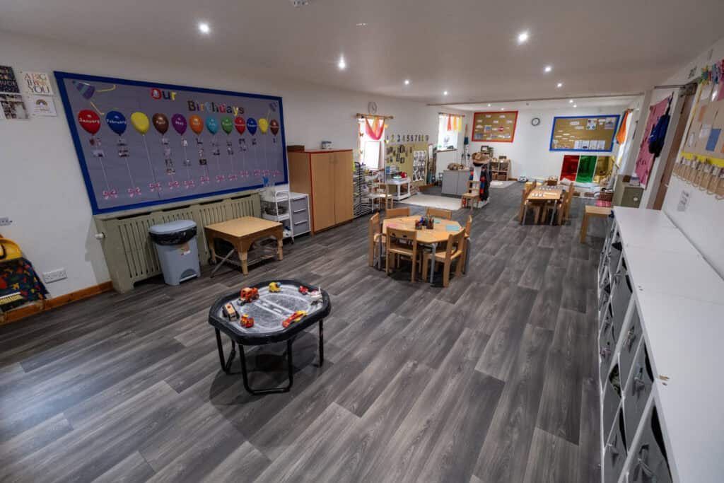 Bright and welcoming childcare classroom at Thrive Childcare with colourful decorations, low tables for children, and engaging educational play areas. Ideal for early childhood development and learning.