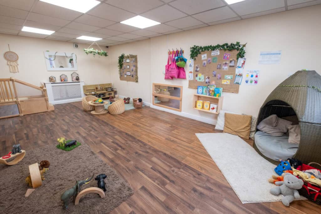 Bright and welcoming nursery playroom at Thrive Childcare, designed for early childhood development with comfortable seating, toys, educational materials, and cosy reading nook.