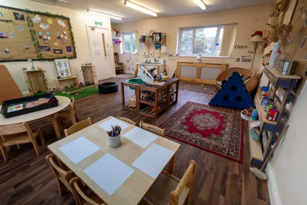 Bright, welcoming indoor childcare playroom with colourful educational activities, cosy reading corner, arts and crafts materials, soft mats, and engaging toys, perfect for early childhood development.