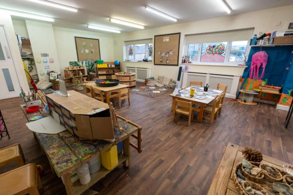 Bright and inviting childcare classroom in Thrive Childcare with active learning areas, craft tables, and sensory play zones for children.