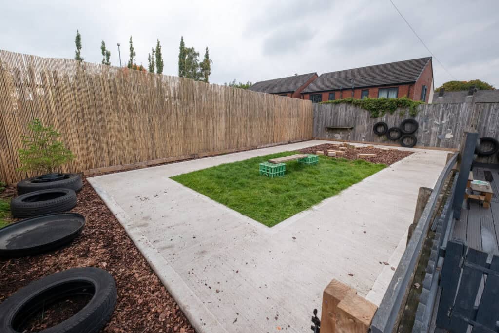 Bright outdoor play area at Thrive Childcare with safe grass and sensory play elements, ideal for early childhood development and outdoor activities.
