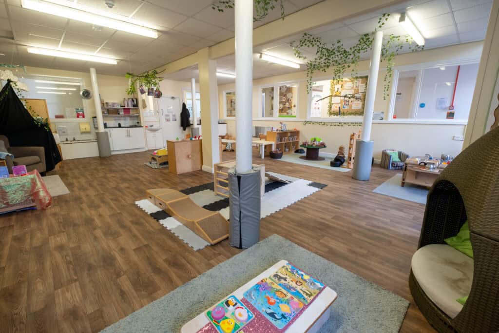 Bright, spacious indoor childcare play area with age-appropriate toys, soft mats, and learning stations, ideal for supporting early childhood development at Thrive Childcare.