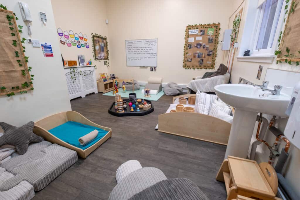 Bright indoor nursery room at Thrive Childcare with play areas, sensory toys, and cozy furnishings for early childhood development and learning.