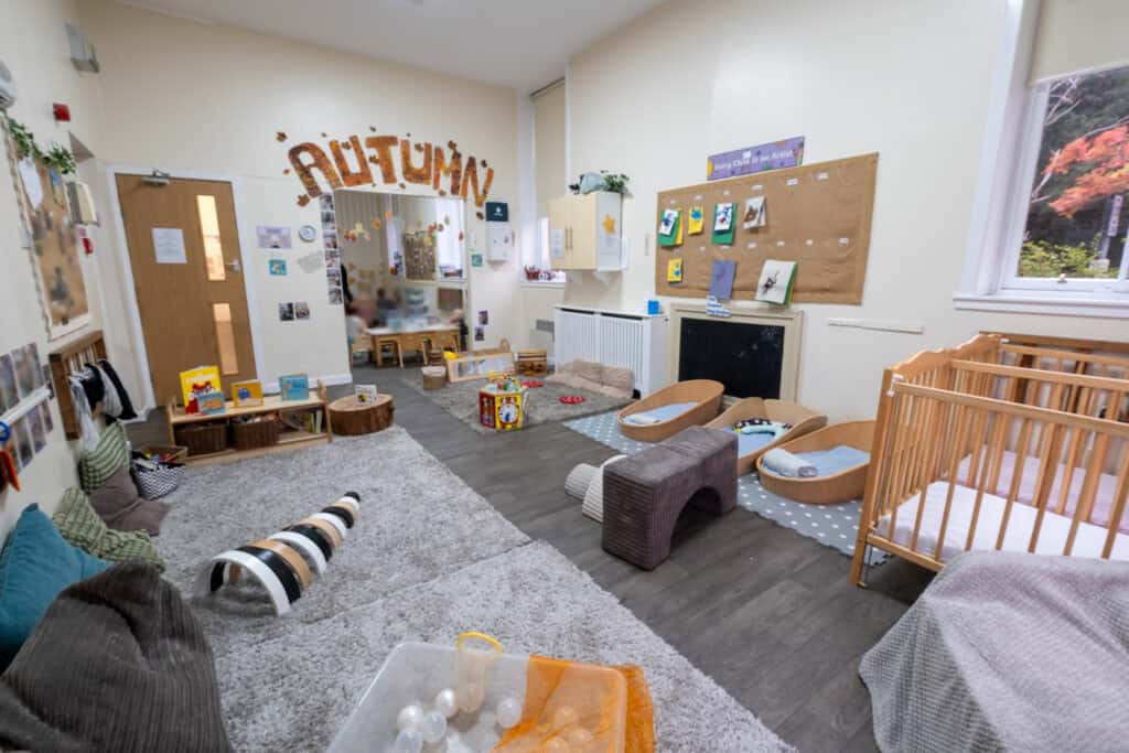Bright and welcoming childcare room at Thrive Childcare, featuring cozy sleeping areas, educational toys, and vibrant artwork, designed to foster early childhood development and creativity.