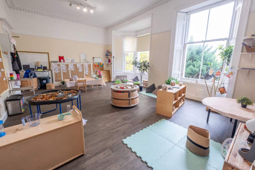 Bright and welcoming nursery room at Thrive Childcare featuring large windows, natural light, child-friendly furniture, and educational toys, creating a safe, nurturing environment for early childhood development.