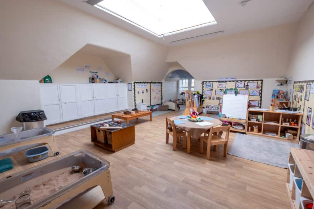 Bright indoor child care classroom at Thrive Childcare with educational displays, activities, and play areas, designed for early childhood development and learning in a safe, nurturing environment.