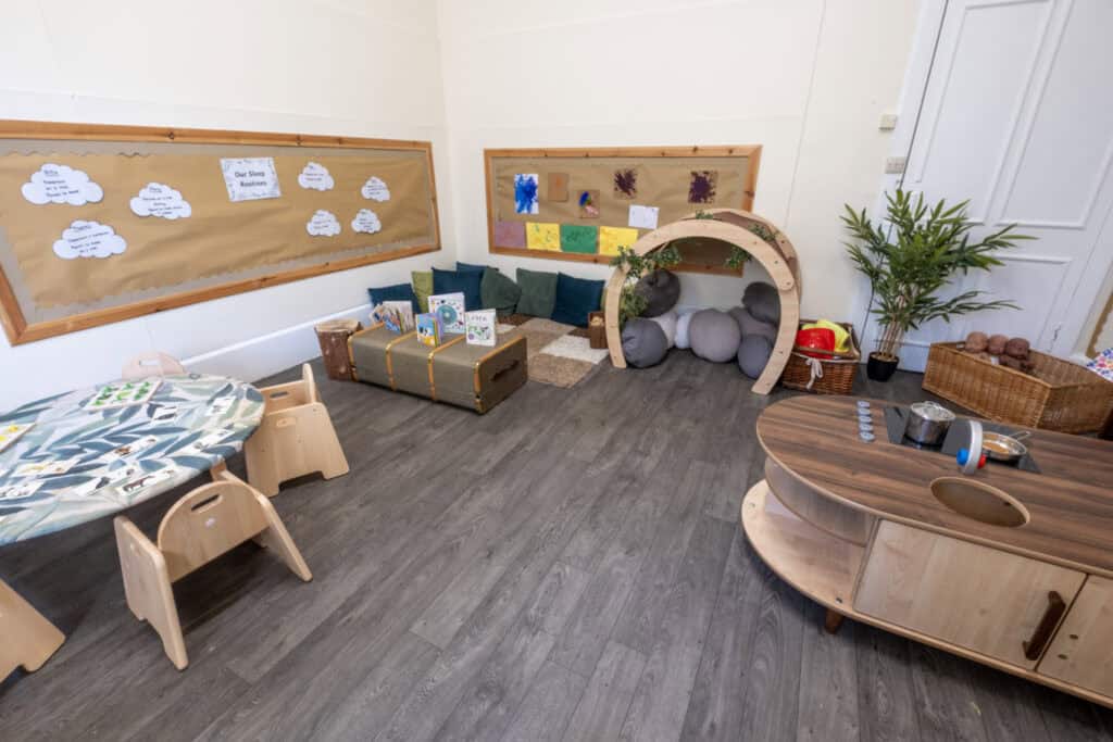 Bright indoor childcare play area with soft mats, books, cosy cushions, and sensory toys, promoting fun and learning in a safe environment at Thrive Childcare.